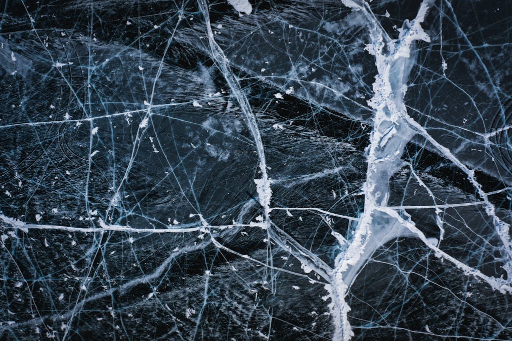 Textured background of icy lake with cracks